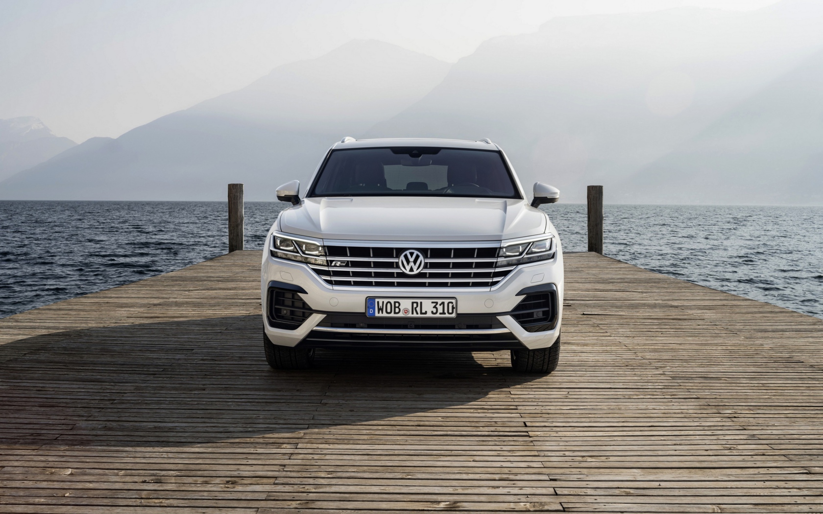 Белый автомобиль Volkswagen Touareg, 2018 года на мосту
