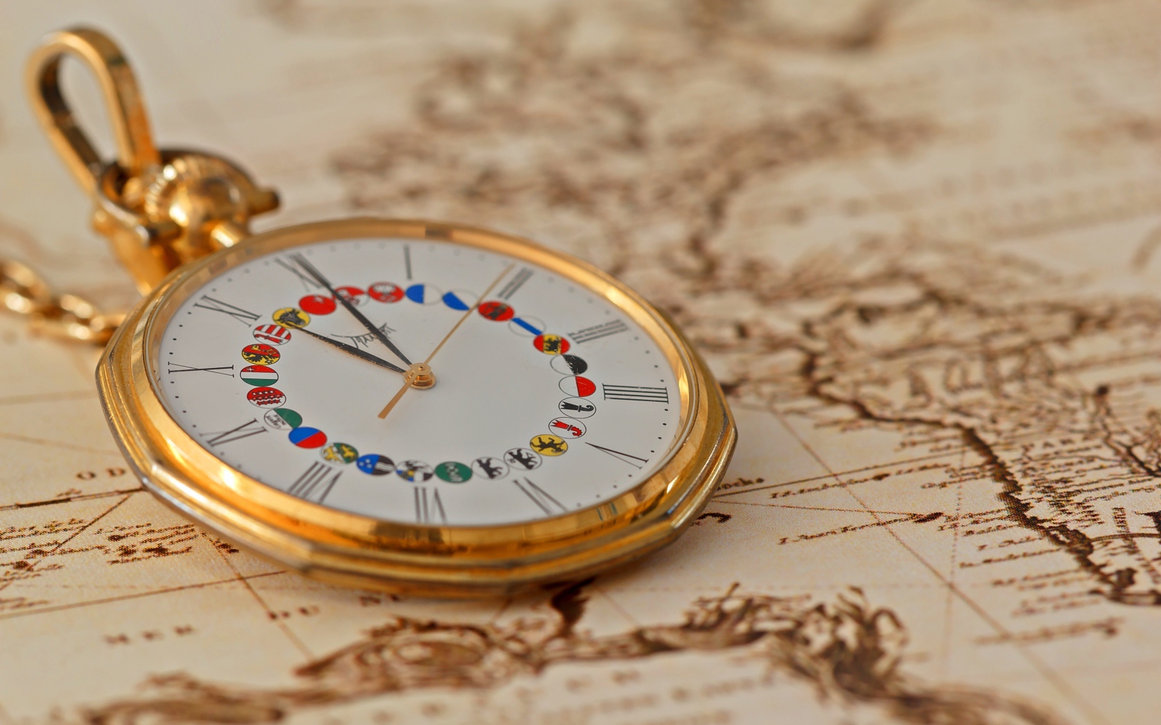 Карманные часы в золотой оправе лежат на карте