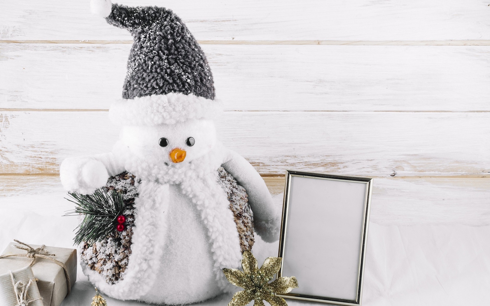 Большой игрушечный снеговик на деревянном фоне
