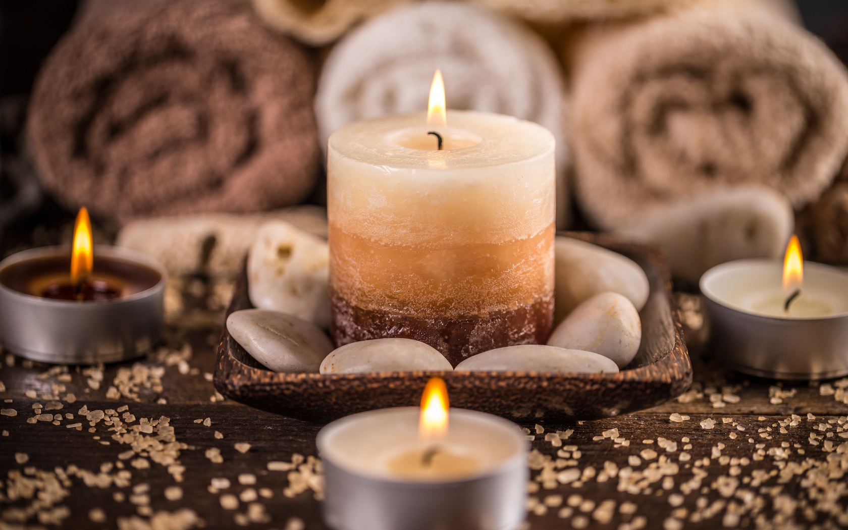 Зажженная свеча с камнями для SPA процедур