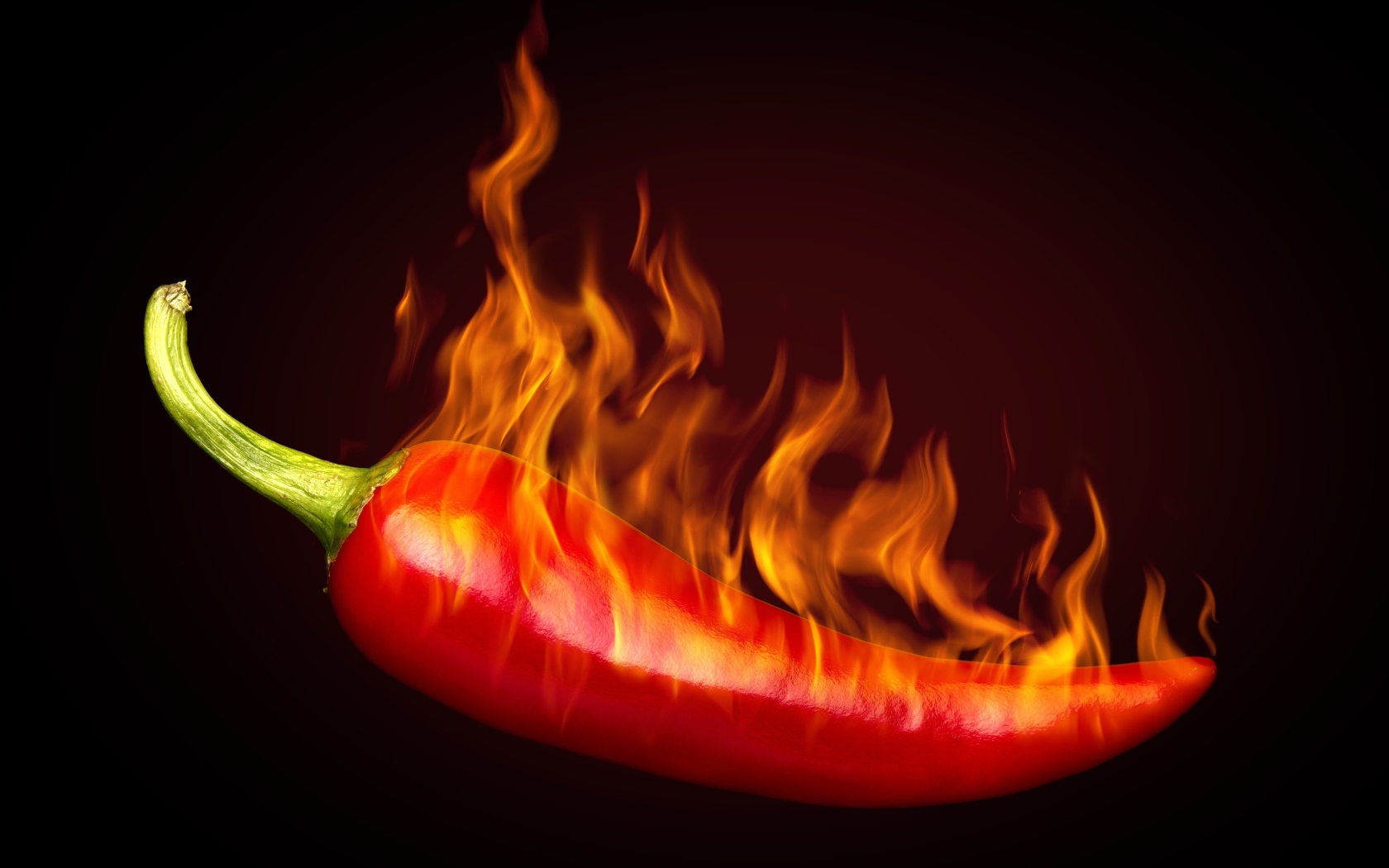 Красный перец с пламенем на черном фоне