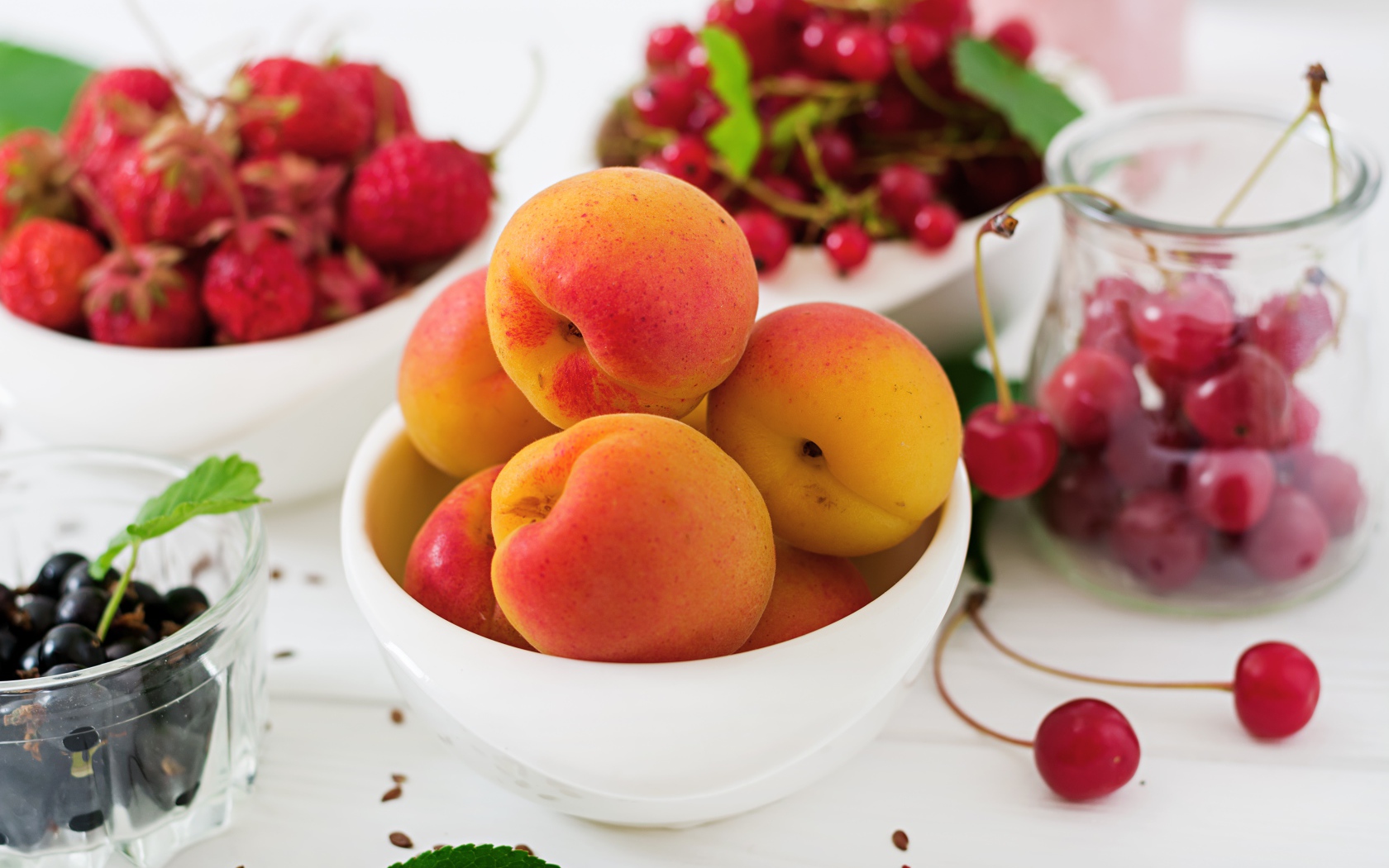 Свежие абрикосы на столе с ягодами крупным планом