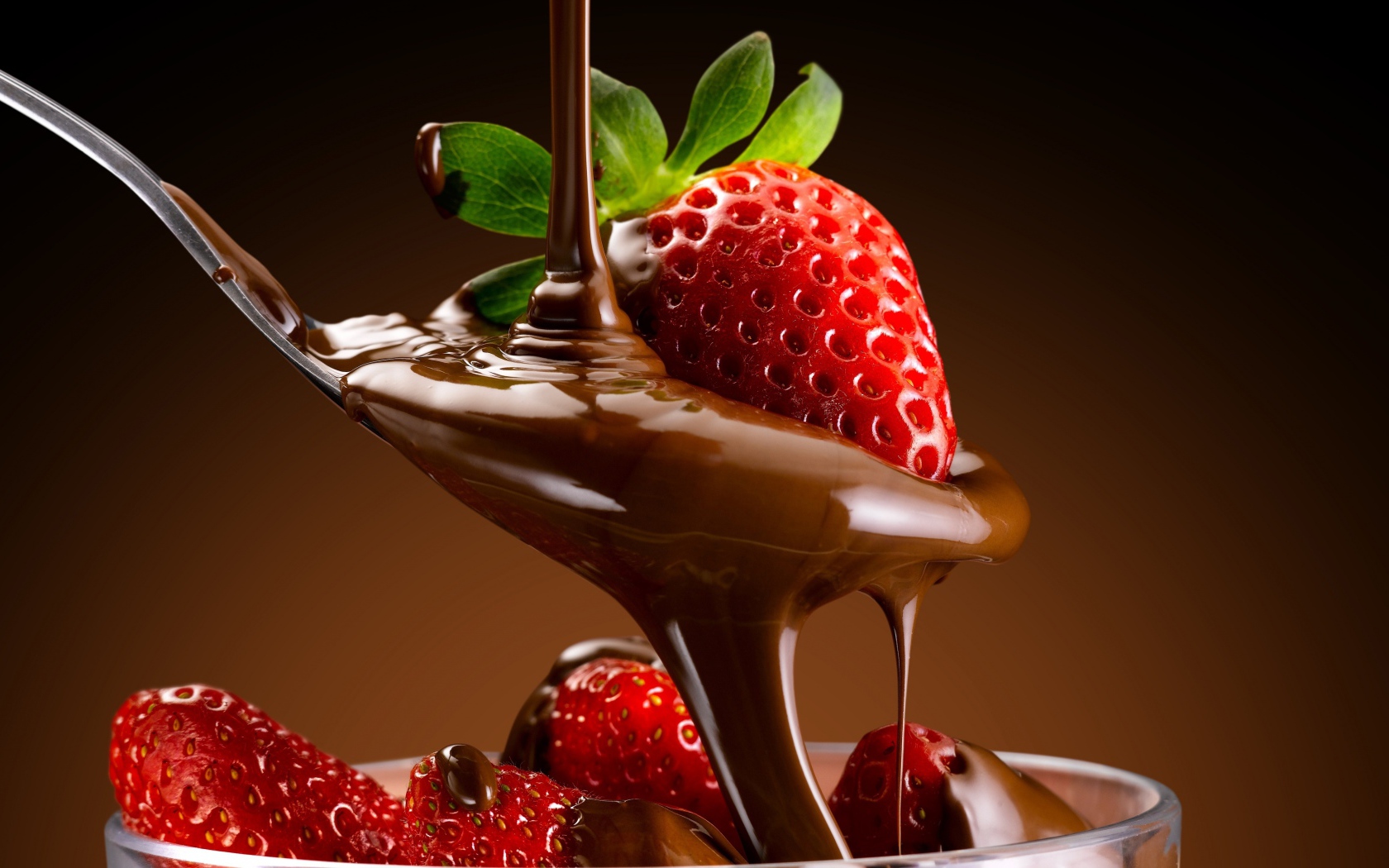 Свежая красная клубника на ложке с шоколадной пастой