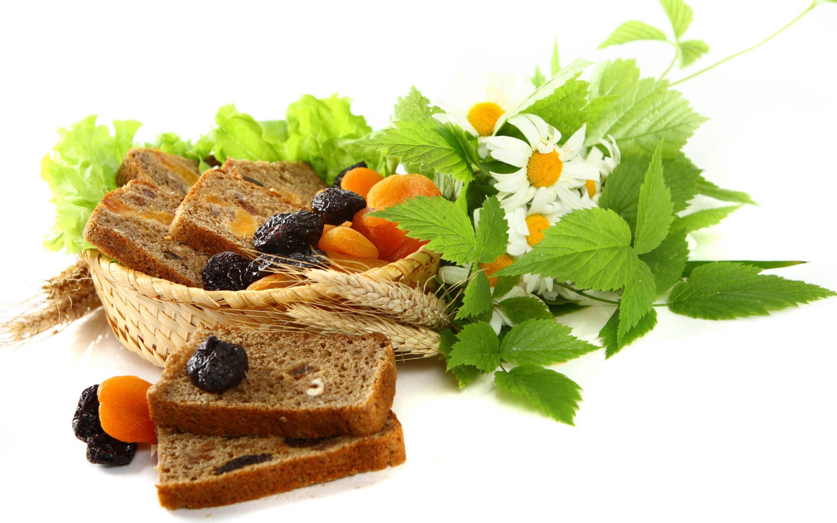 Сухофрукты с хлебом и цветами ромашки на белом фоне