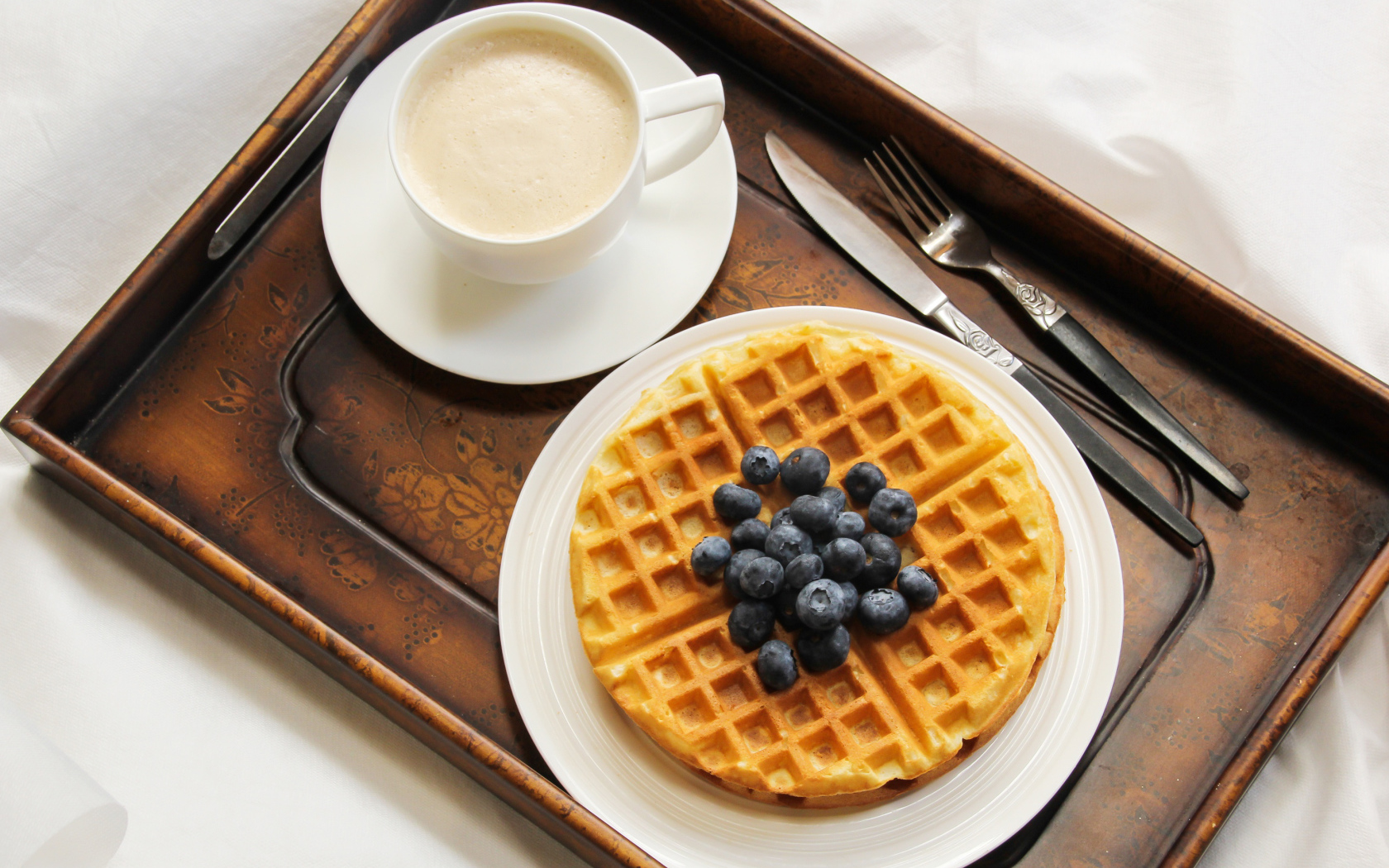 Чашка кофе и сладкие вафли с черникой на завтрак