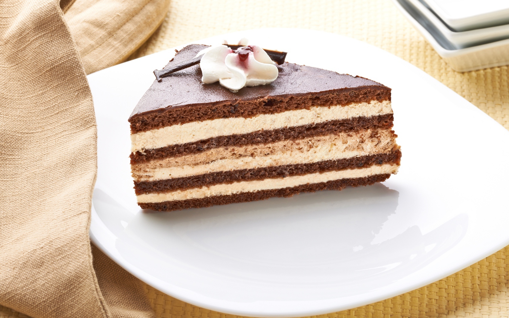 Большой кусок торта с кремом украшен цветком