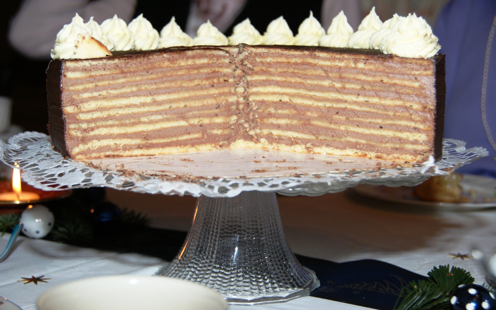 Разрезанный торт с кремом на стеклянном блюде