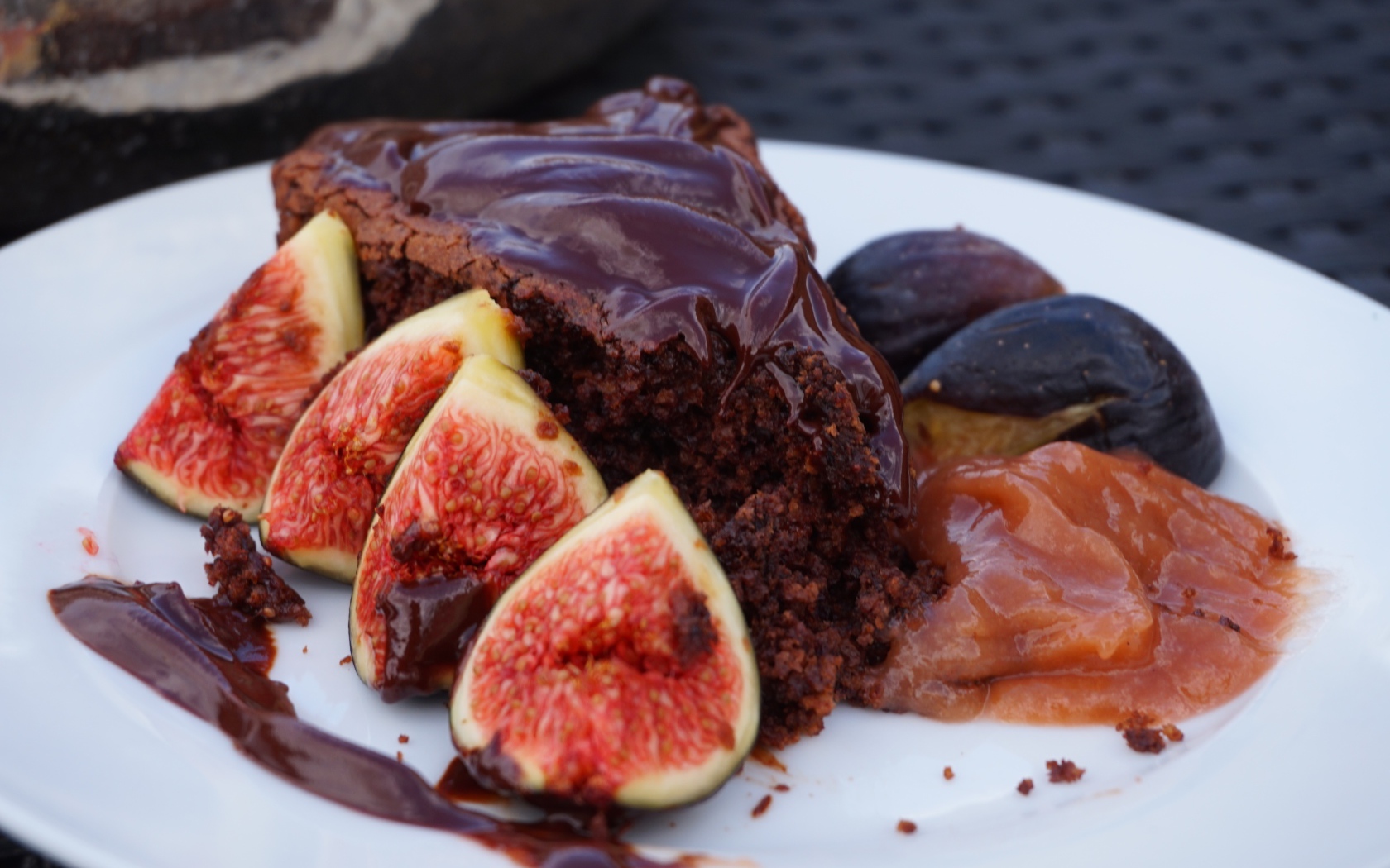 Кусок пирога с шоколадом на тарелке с кусочками инжира