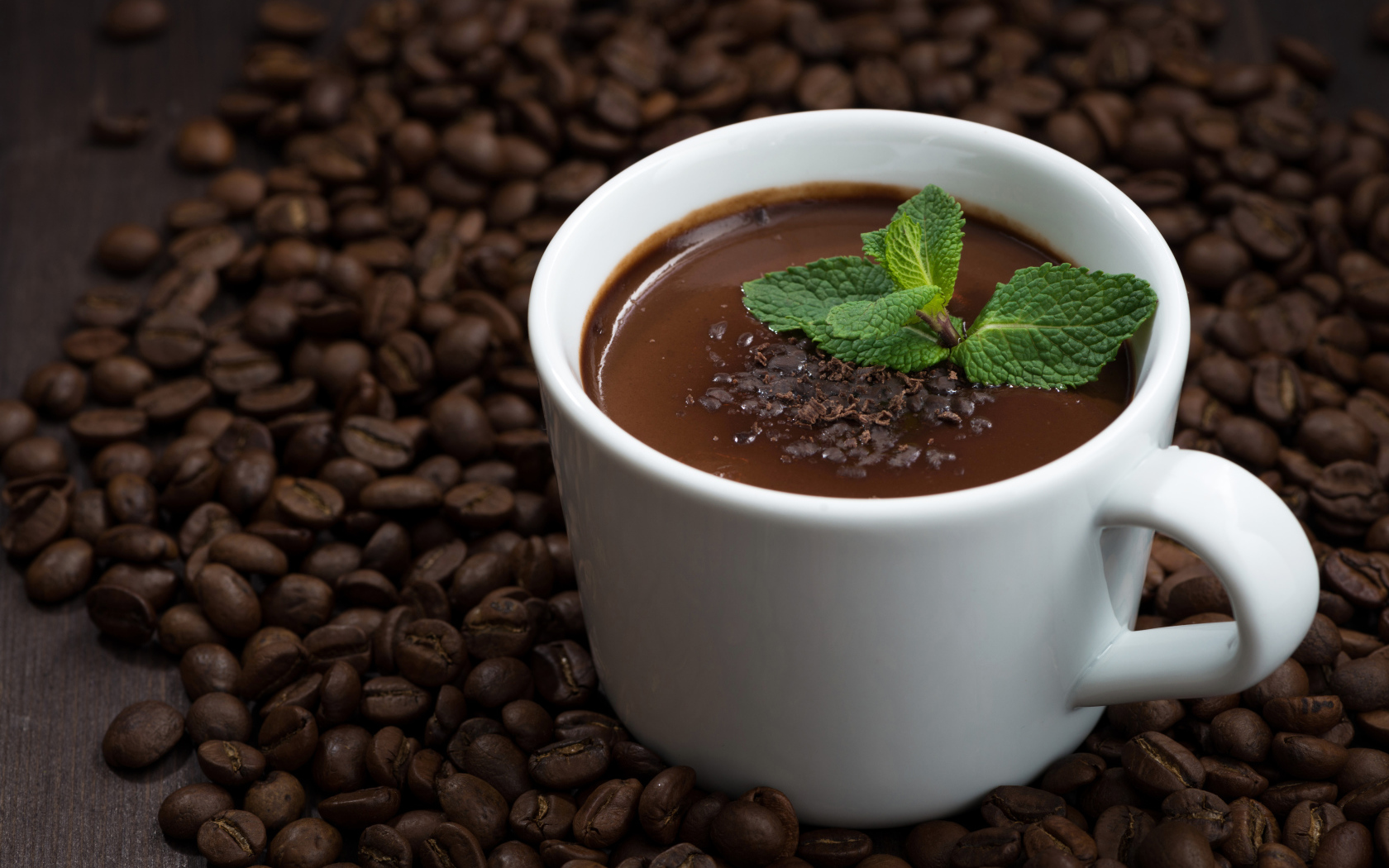Белая чашка горячего шоколада стоит на кофейных зернах