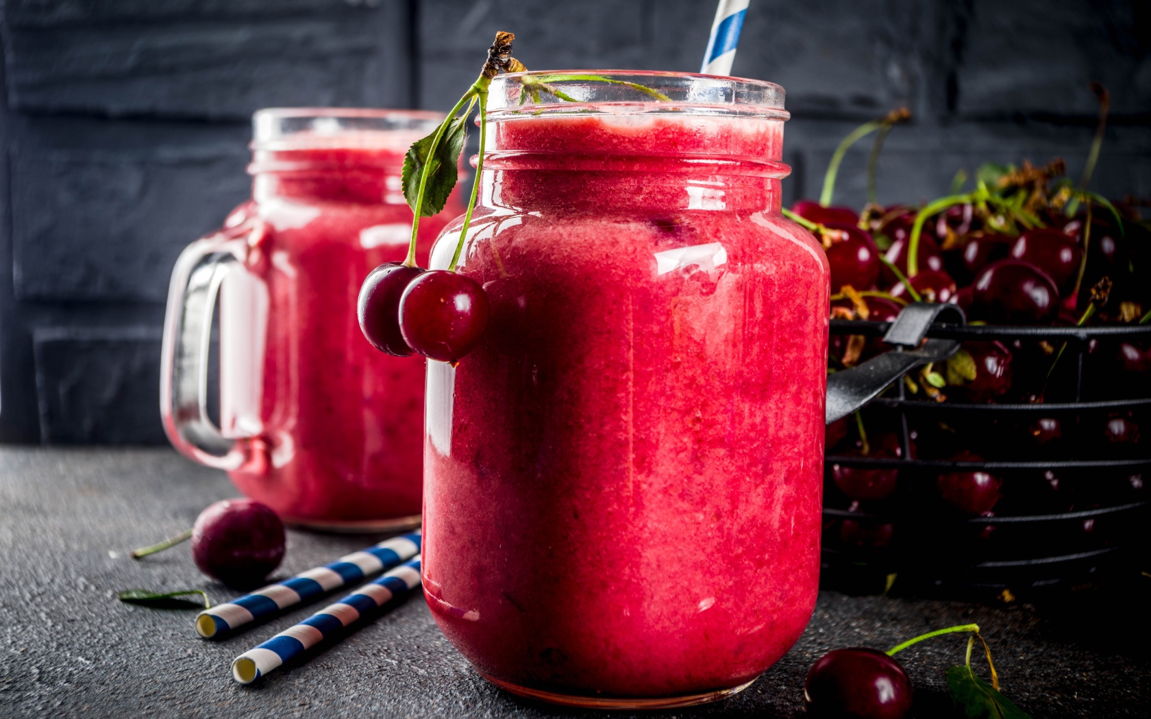 Вишневое смузи в стеклянной банке на столе с ягодами