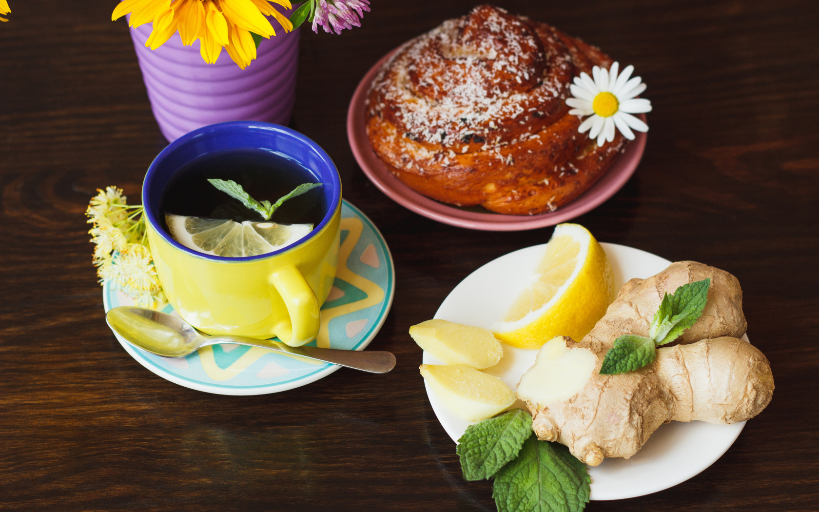 Липовый чай с имбирем и лимоном на столе со свежей булочкой