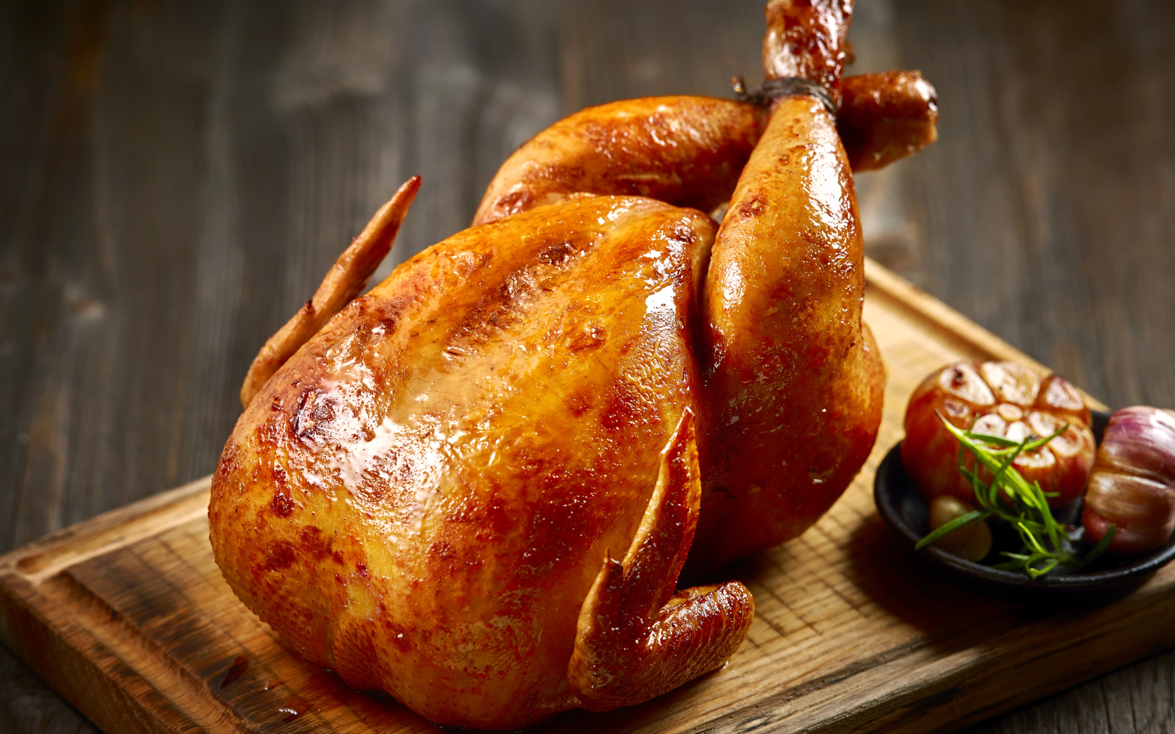 Аппетитная запеченная курица на разделочной доске