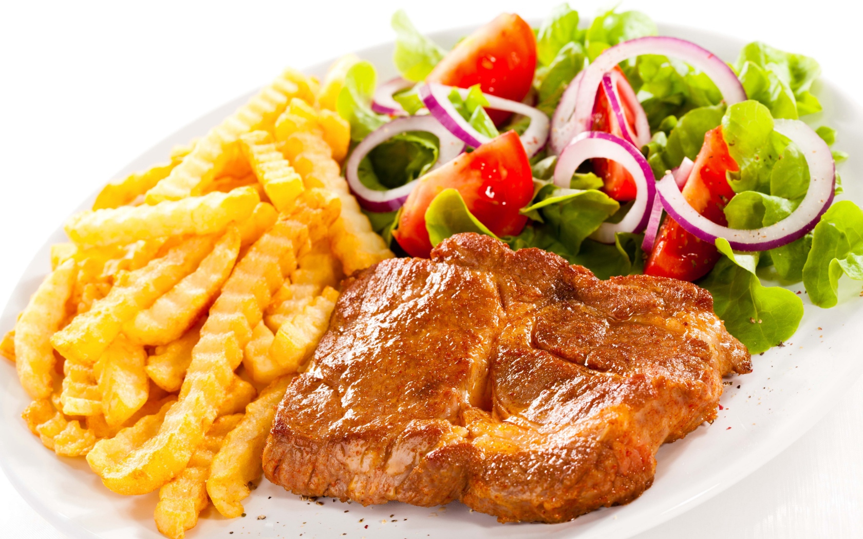 Аппетитная отбивная на тарелке с картофелем фри и салатом