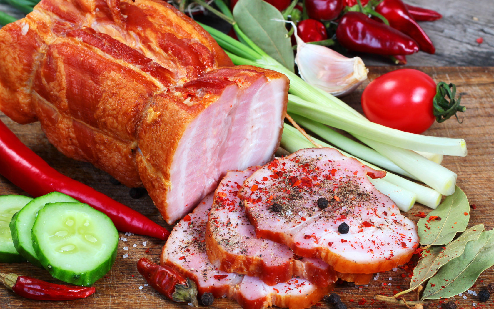 Аппетитная ветчина со специями и свежими овощами на столе
