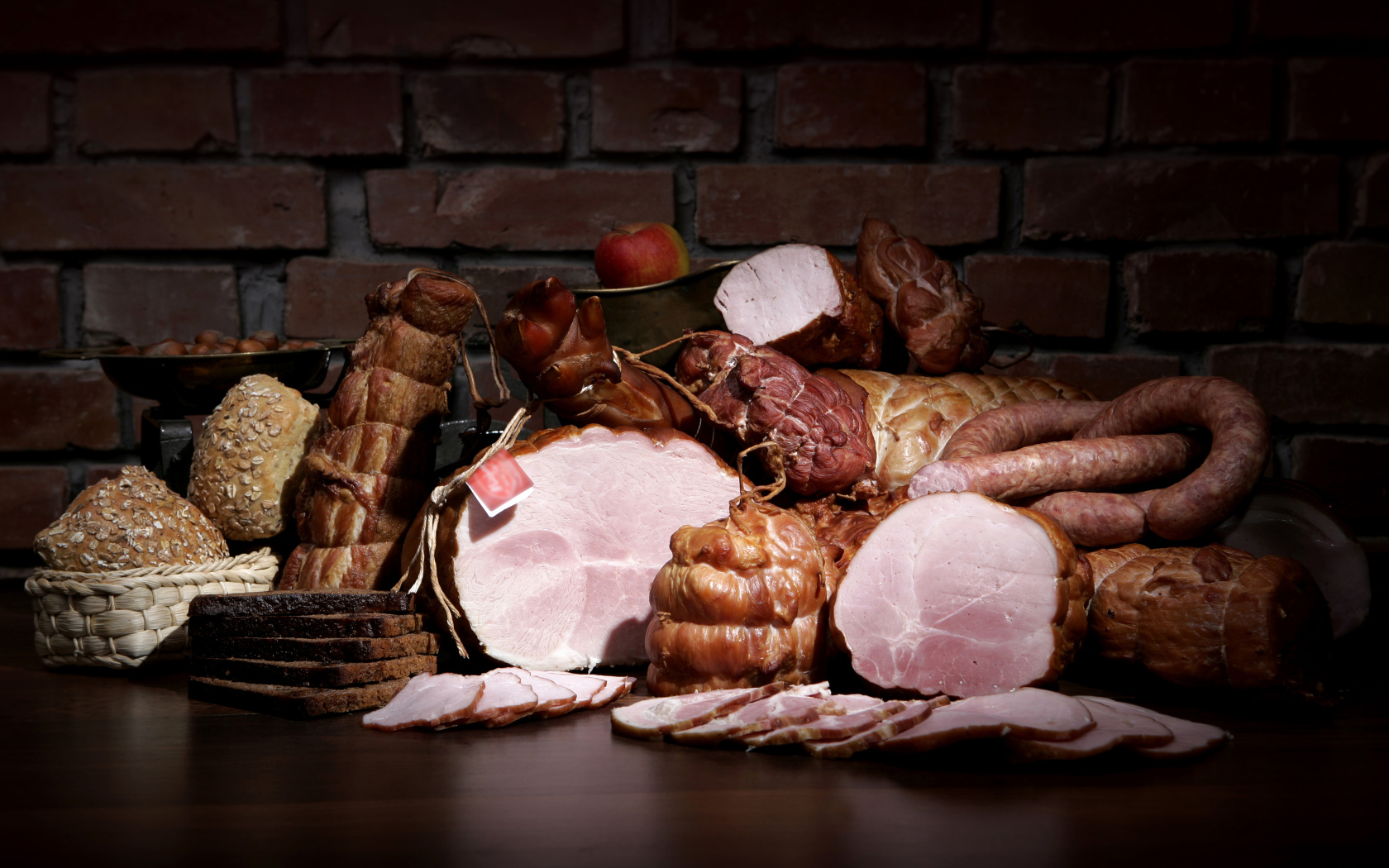 Аппетитные мясные продукты на фоне кирпичной стены 