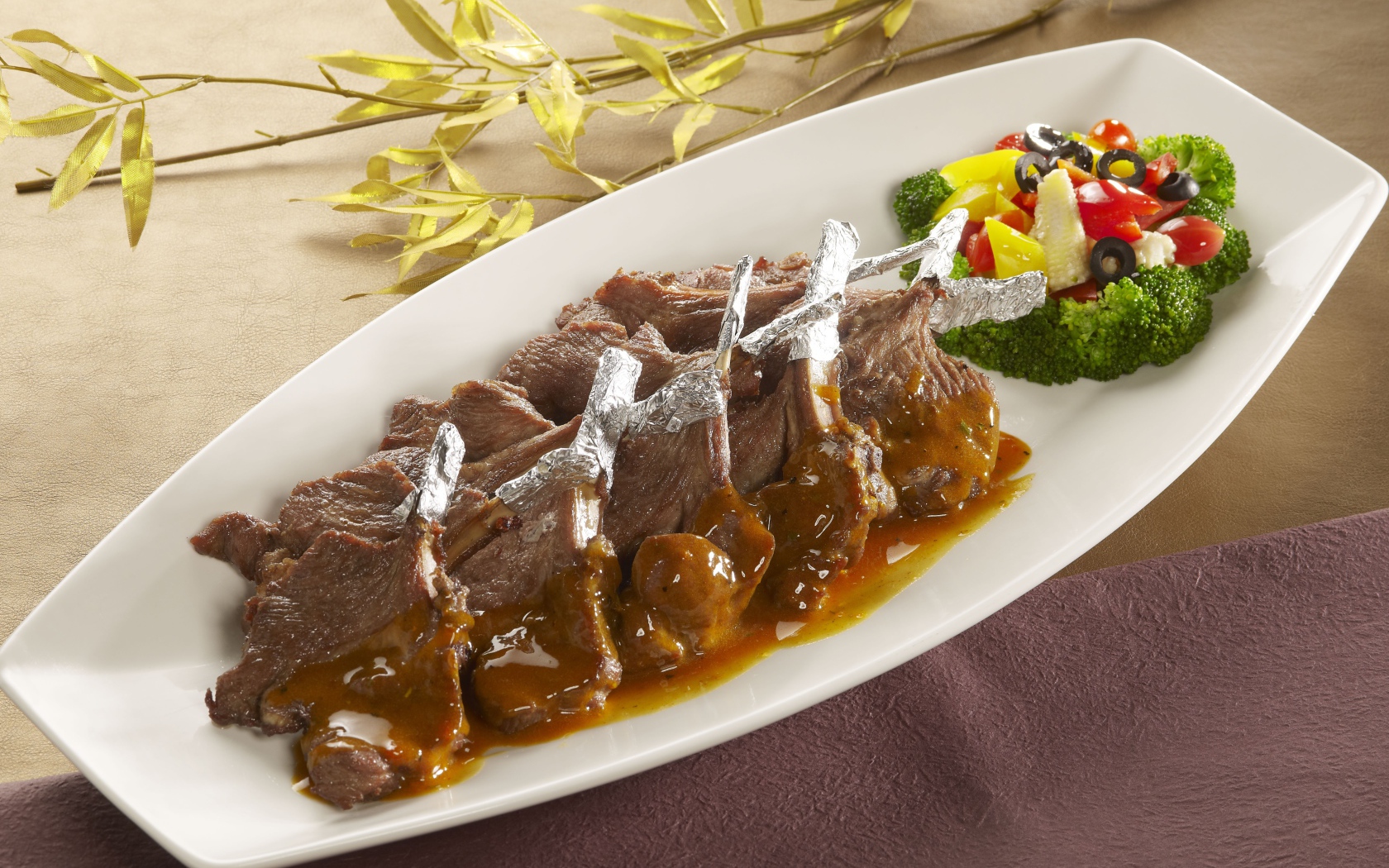 Мясо на белой тарелке с соусом и овощами 