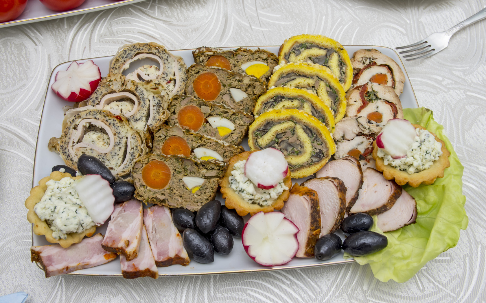 Мясные рулеты на тарелке с оливками 