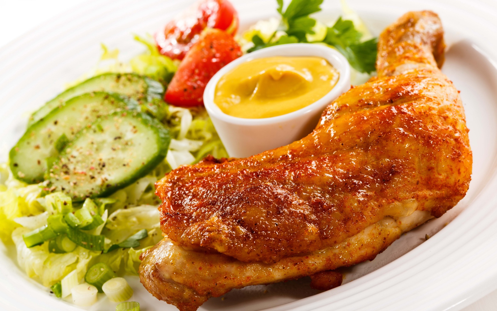 Жареная куриная ножка с овощами и соусом на тарелке