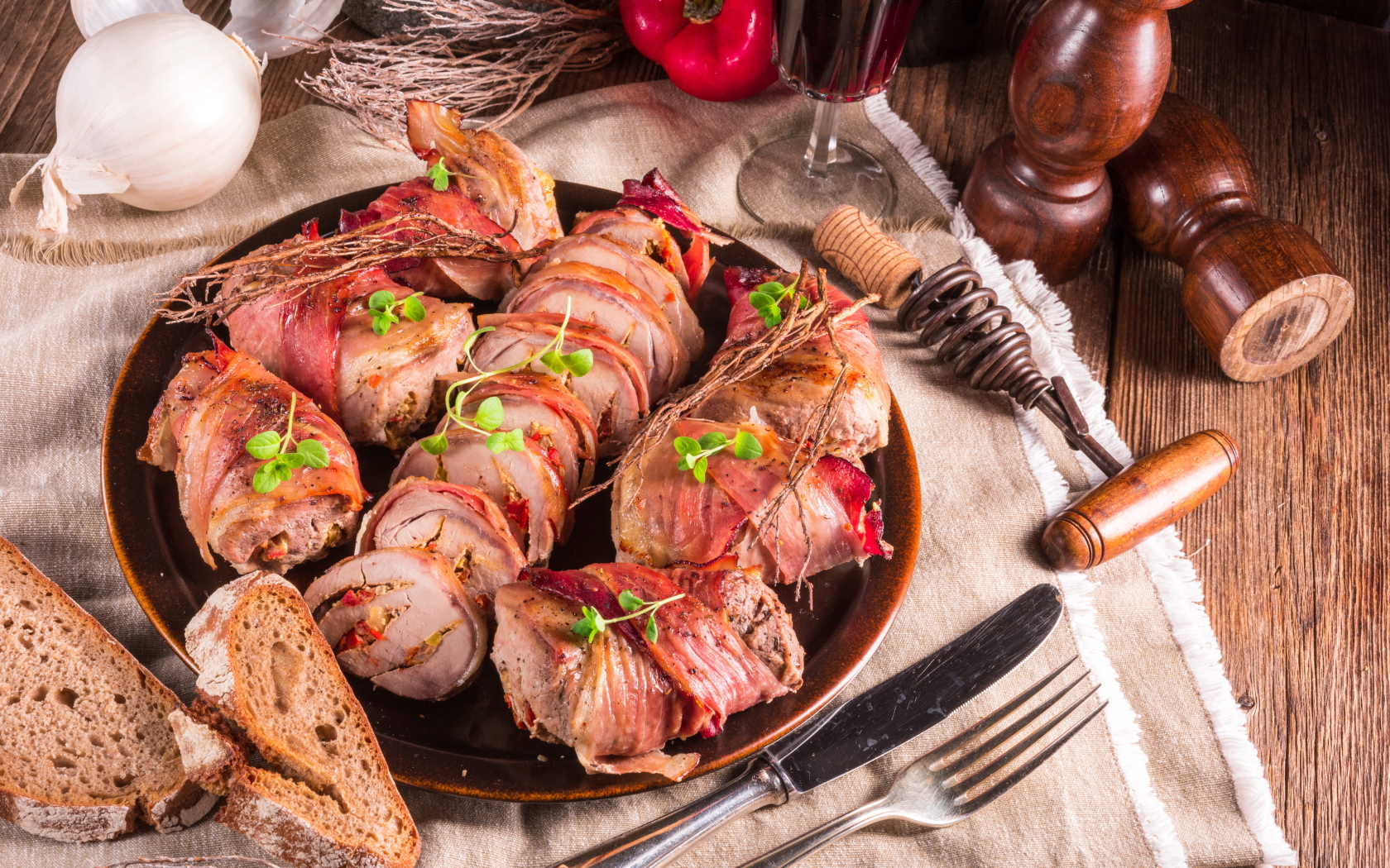 Нарезанные мясные рулеты на столе с хлебом