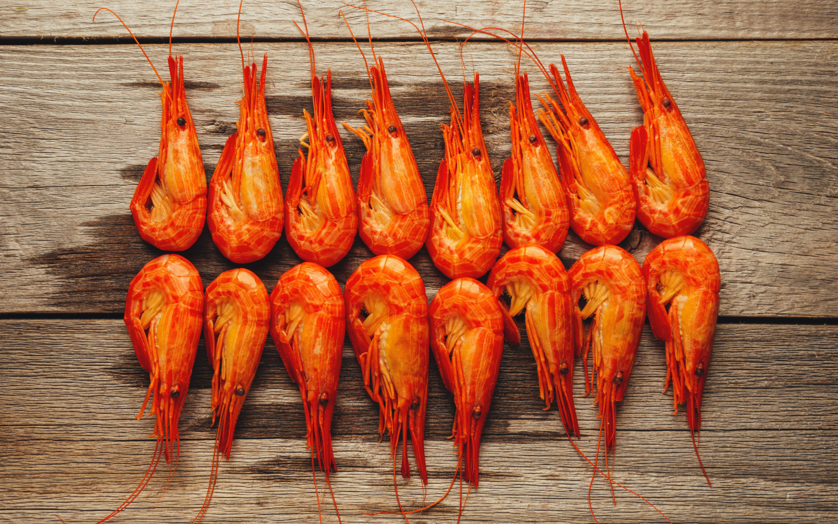 Красные вареные креветки на деревянном столе