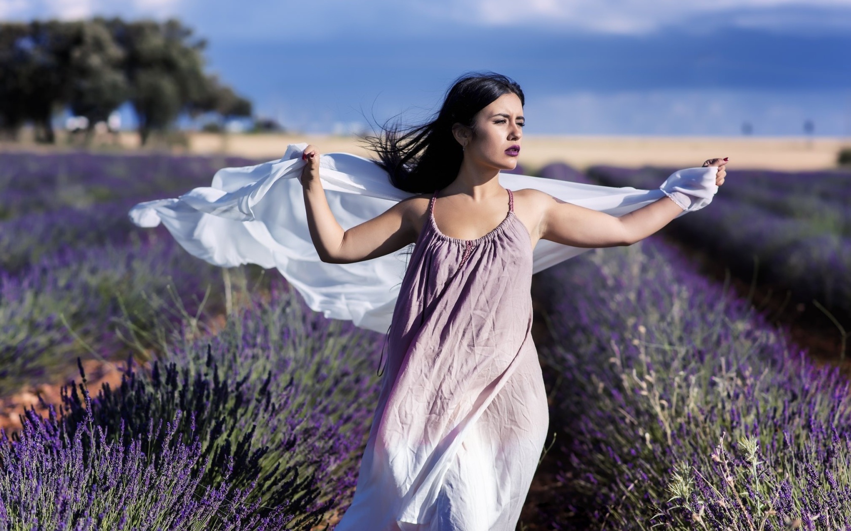 Красивая брюнетка в сарафане гуляет по лавандовому полю