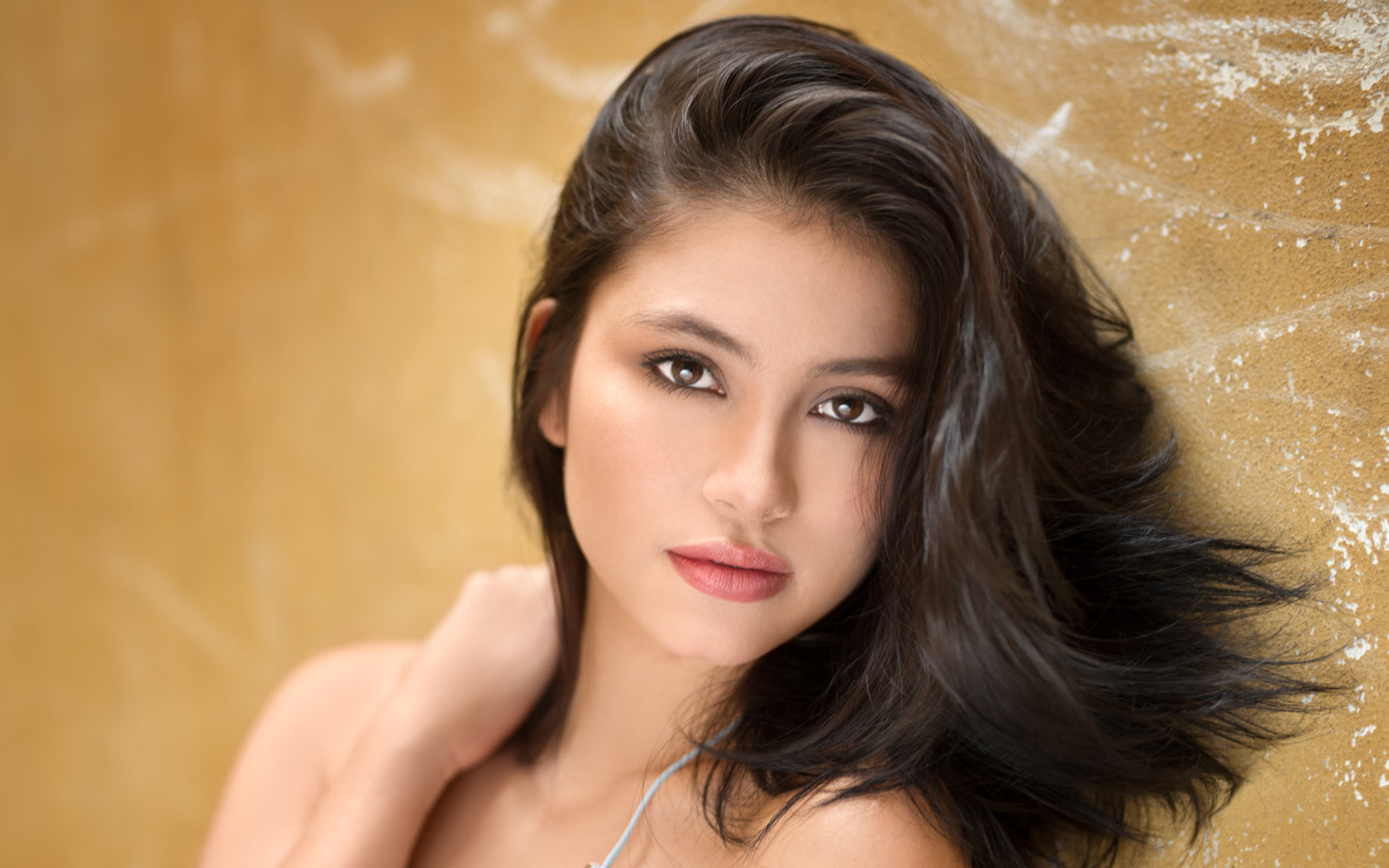 Красивая брюнетка на фоне стены 