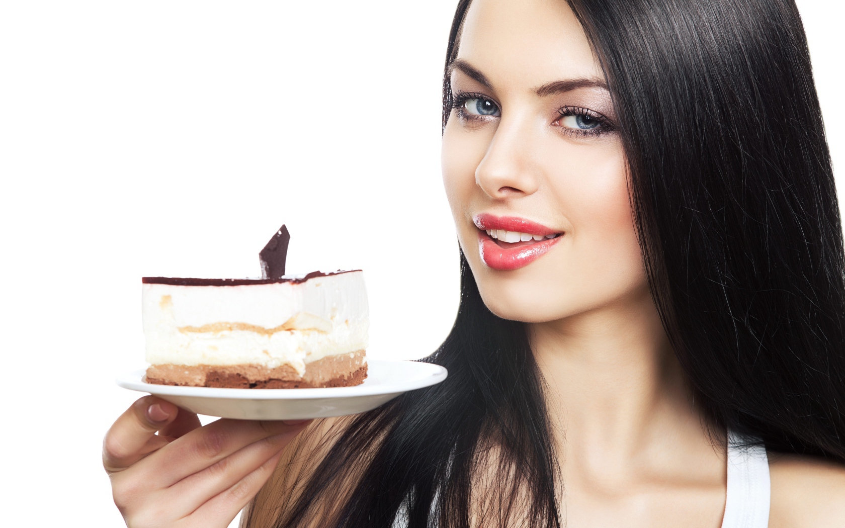 Красивая брюнетка с куском торта на блюдце