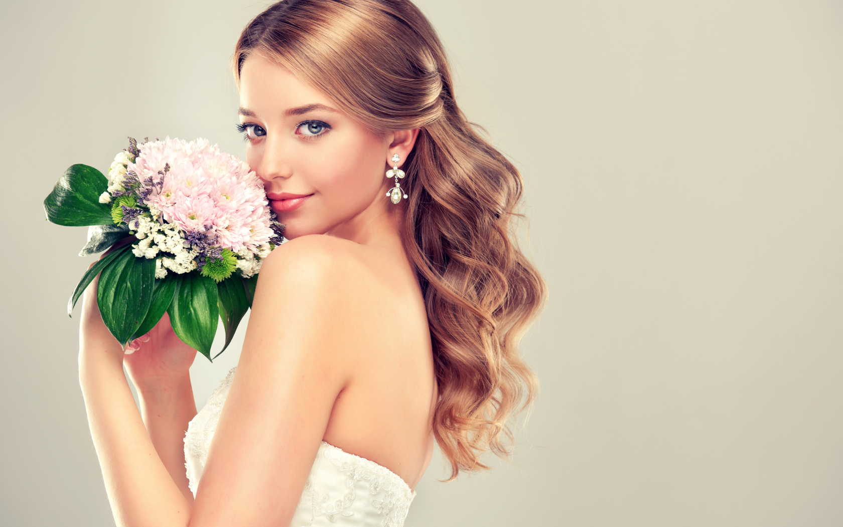 Красивая девушка невеста с букетом цветов на сером фоне