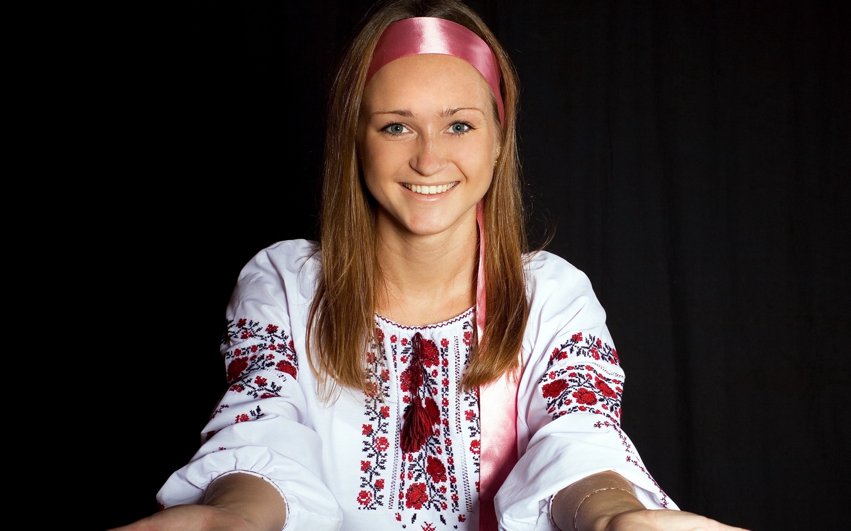 Красивая девушка в вышитой рубашке на черном фоне