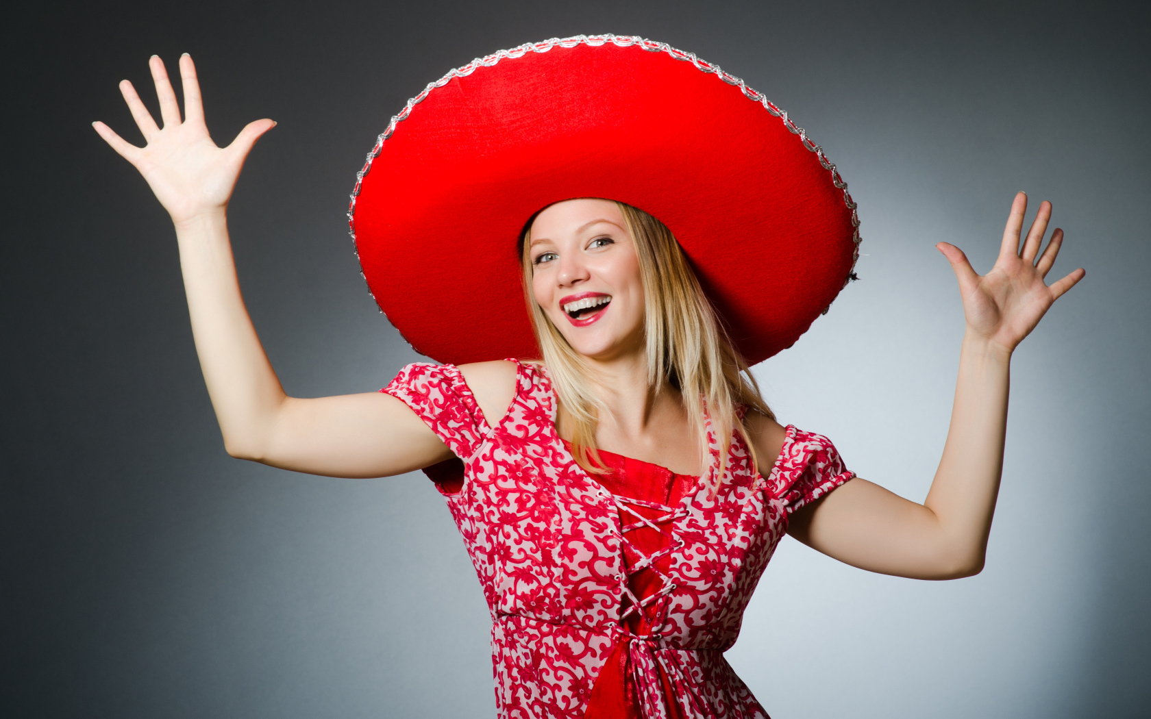 Красивая улыбающаяся блондинка в большой красной шляпе