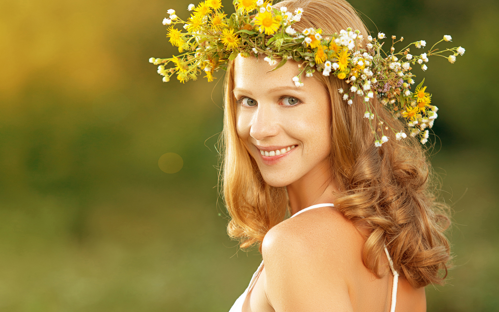 Красивая улыбающаяся девушка с венком из полевых цветов на голове