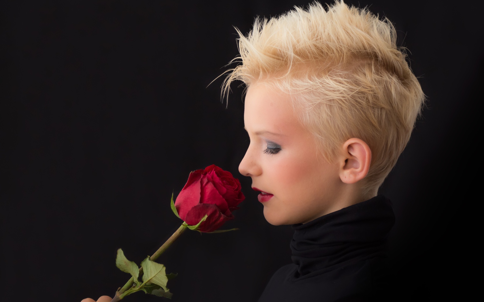 Блондинка с короткой стрижкой с красной розой в руке