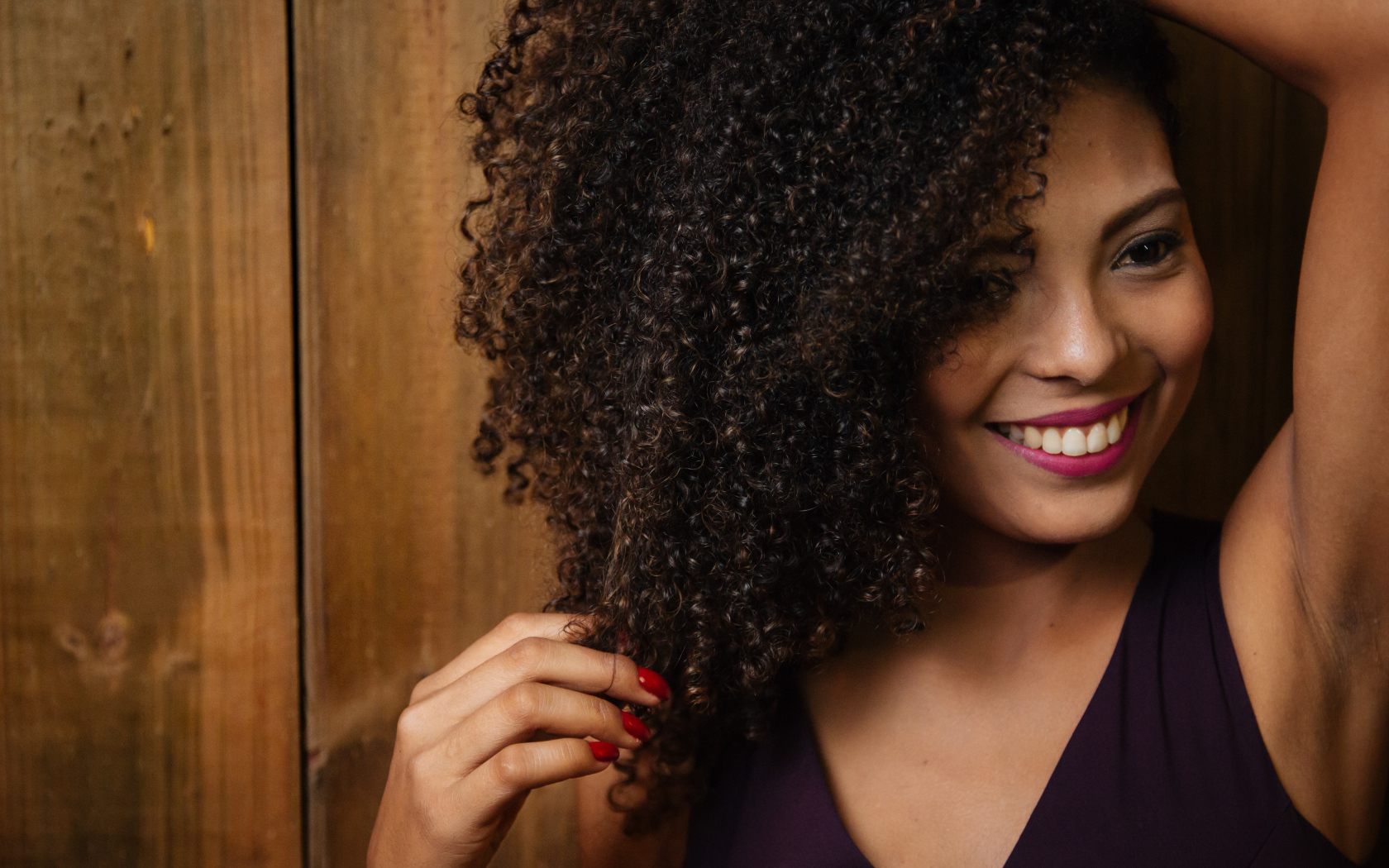 Кучерявая темнокожая девушка с красивой улыбкой 