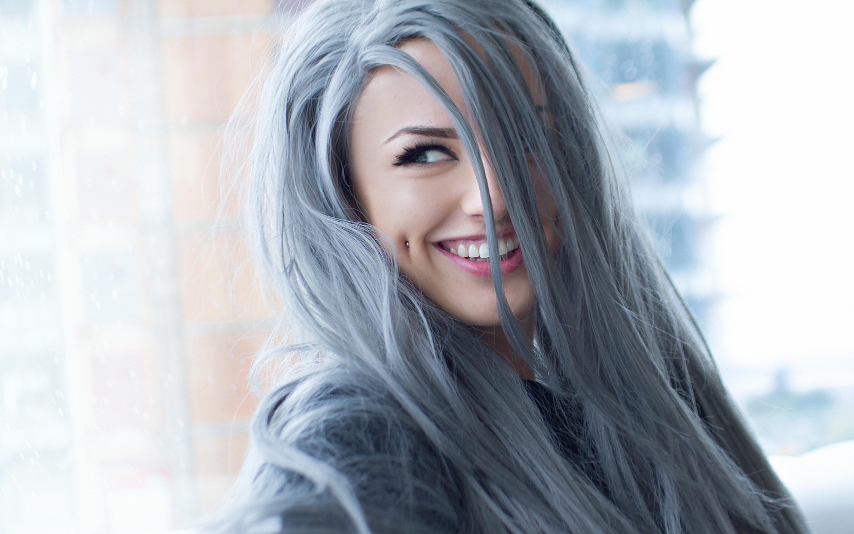 Улыбающаяся эпатажная девушка с пирсингом