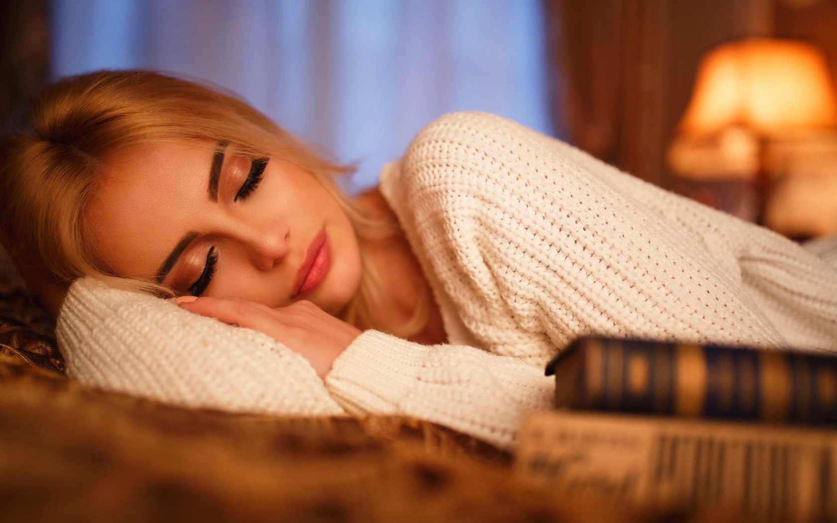 Нежная спящая блондинка в белом свитере 