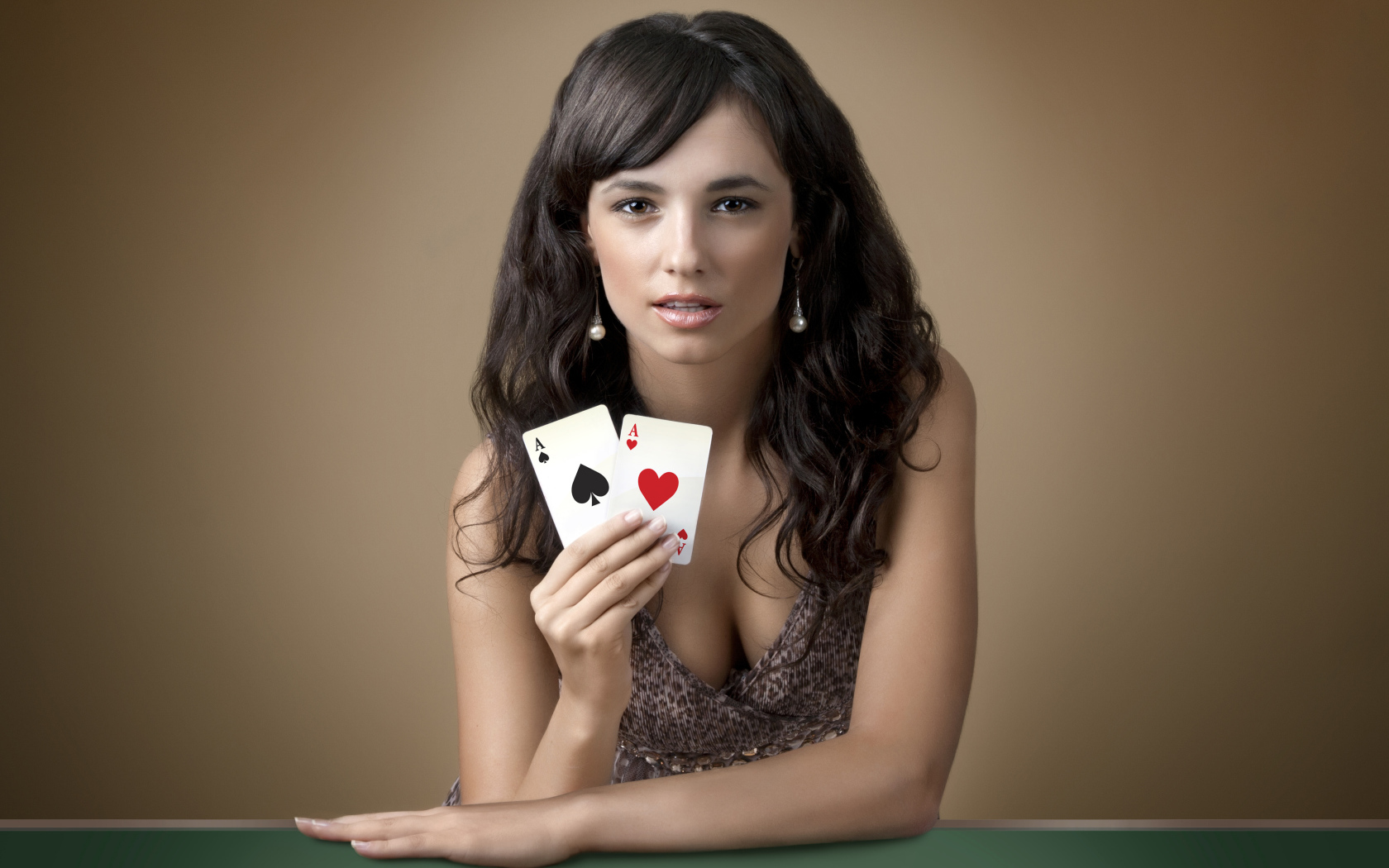 Молодая брюнетка с двумя карточными тузами в руке