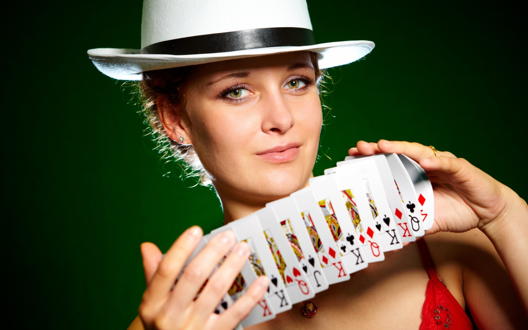Молодая девушка в шляпе с картами в руках