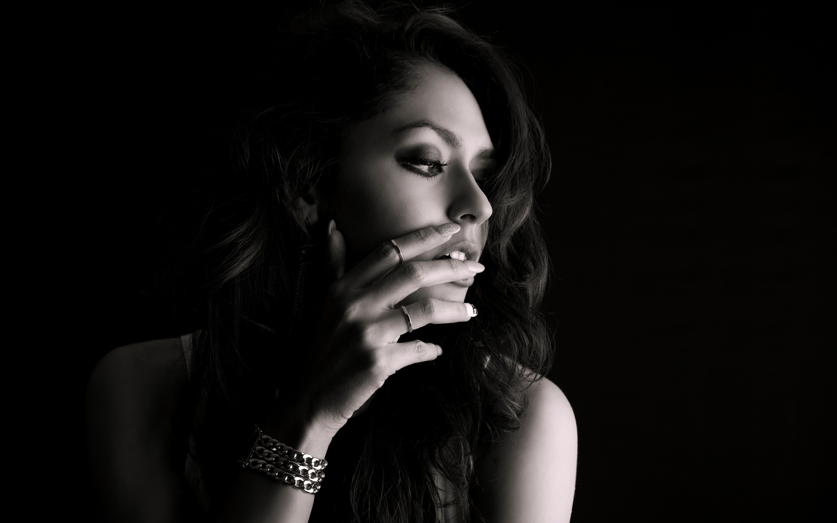 Молодая девушка с украшениями на руке черно-белое фото