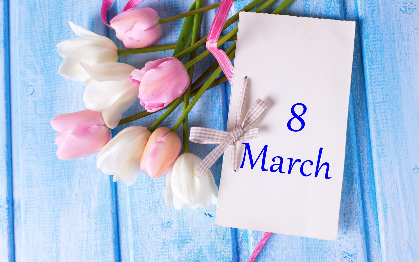 Букет тюльпанов с открыткой на 8 марта на голубом фоне