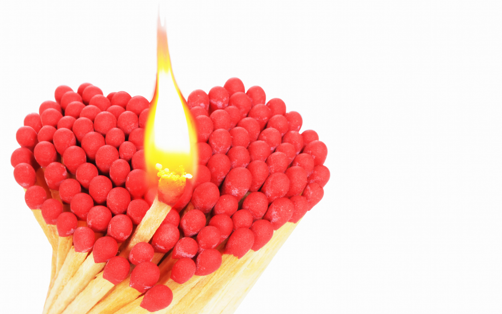 Сердце из спичек с красной серой на белом фоне