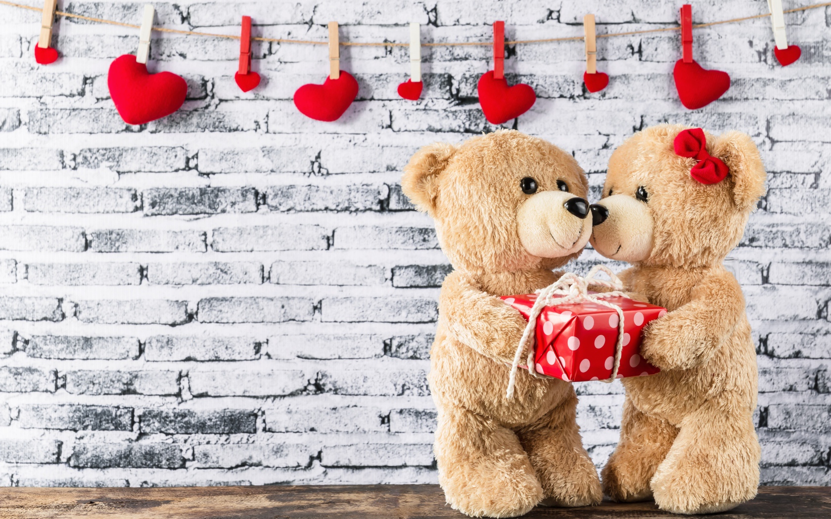 Влюбленные плюшевые мишки на фоне стены с сердечками 