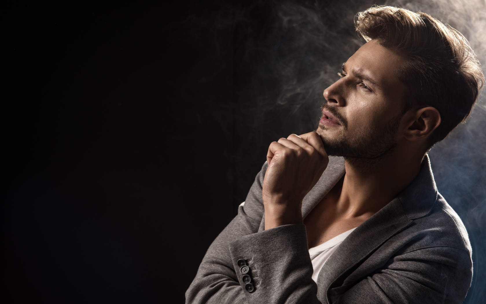 Красивый задумчивый мужчина в сером пиджаке