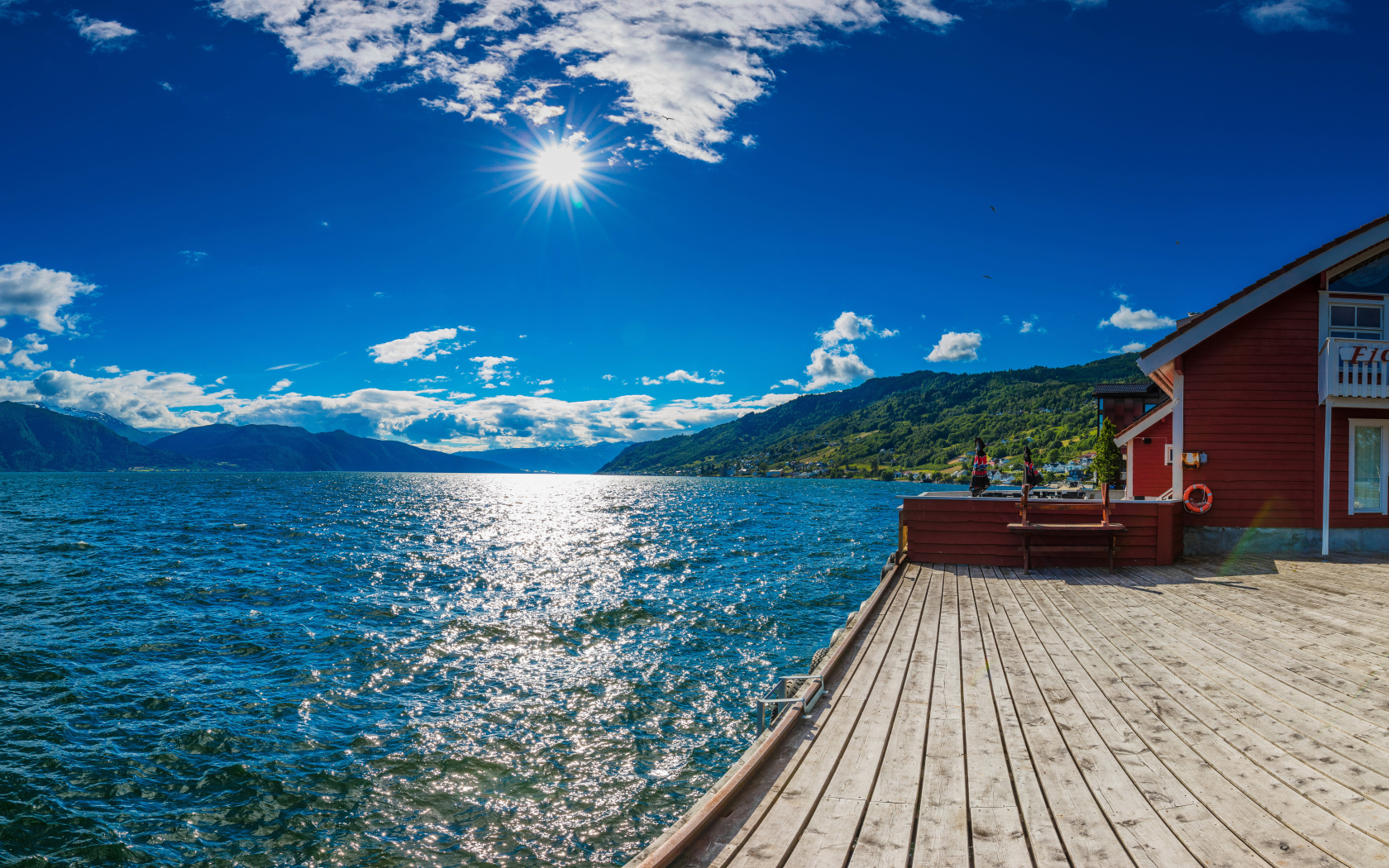 Яркое солнце в голубом небе над водой, Исландия