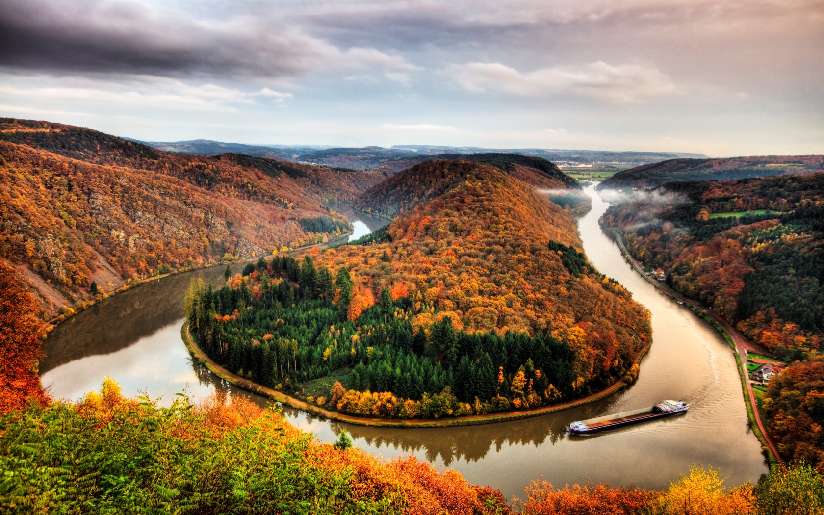 Река рядом с осенним лесом на фоне пасмурного неба