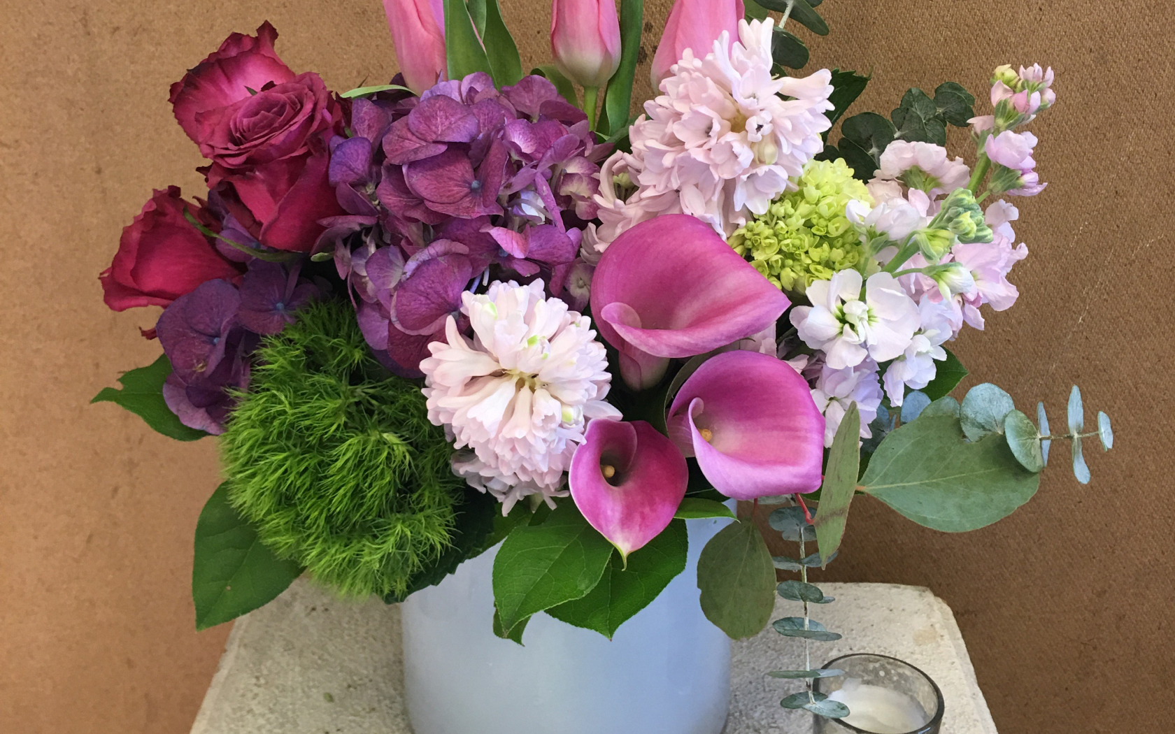 Красивый букет цветов в вазе у стены