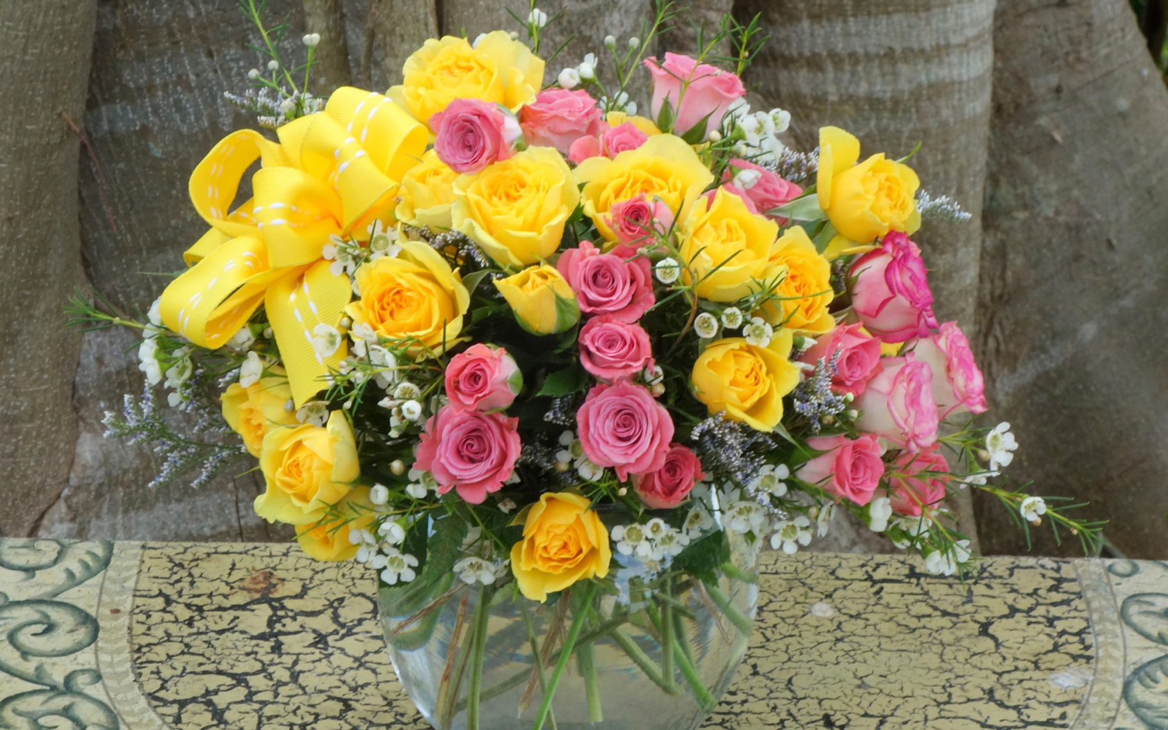 Букет желтых и розовых роз в стеклянной вазе