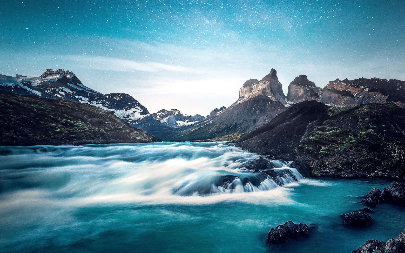 Быстрая вода к реке у гор на фоне голубого неба 