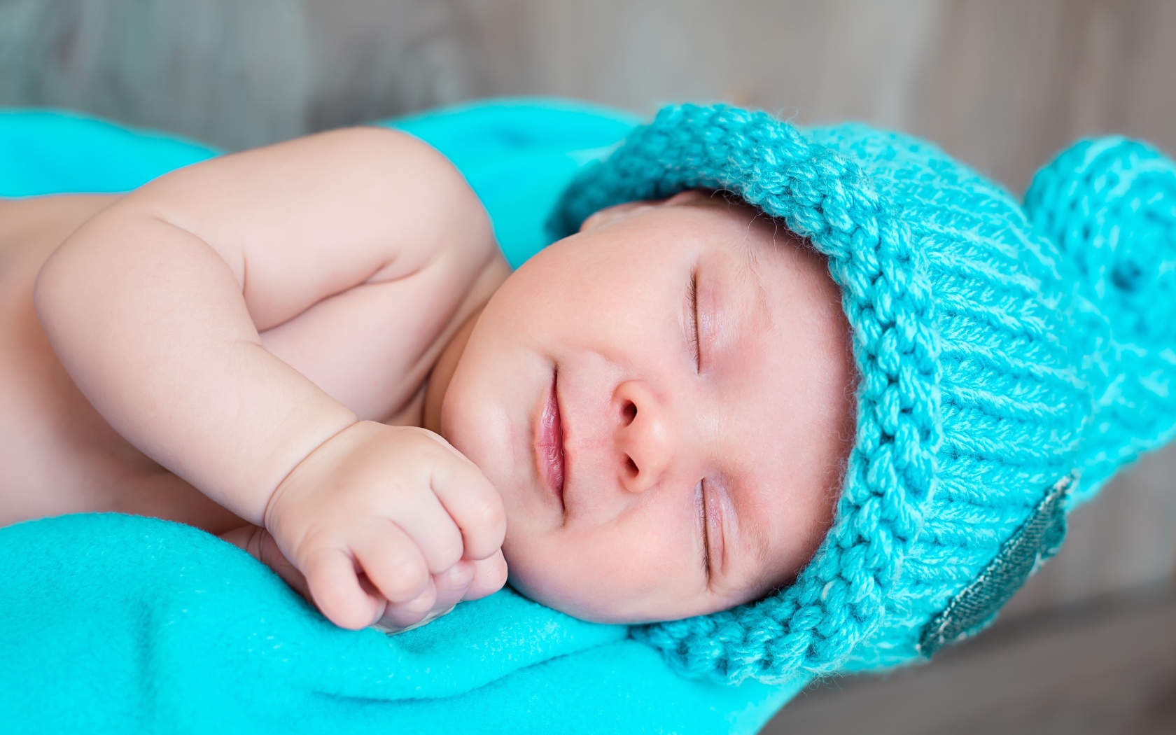 Милый спящий ребенок в голубой вязаной шапке