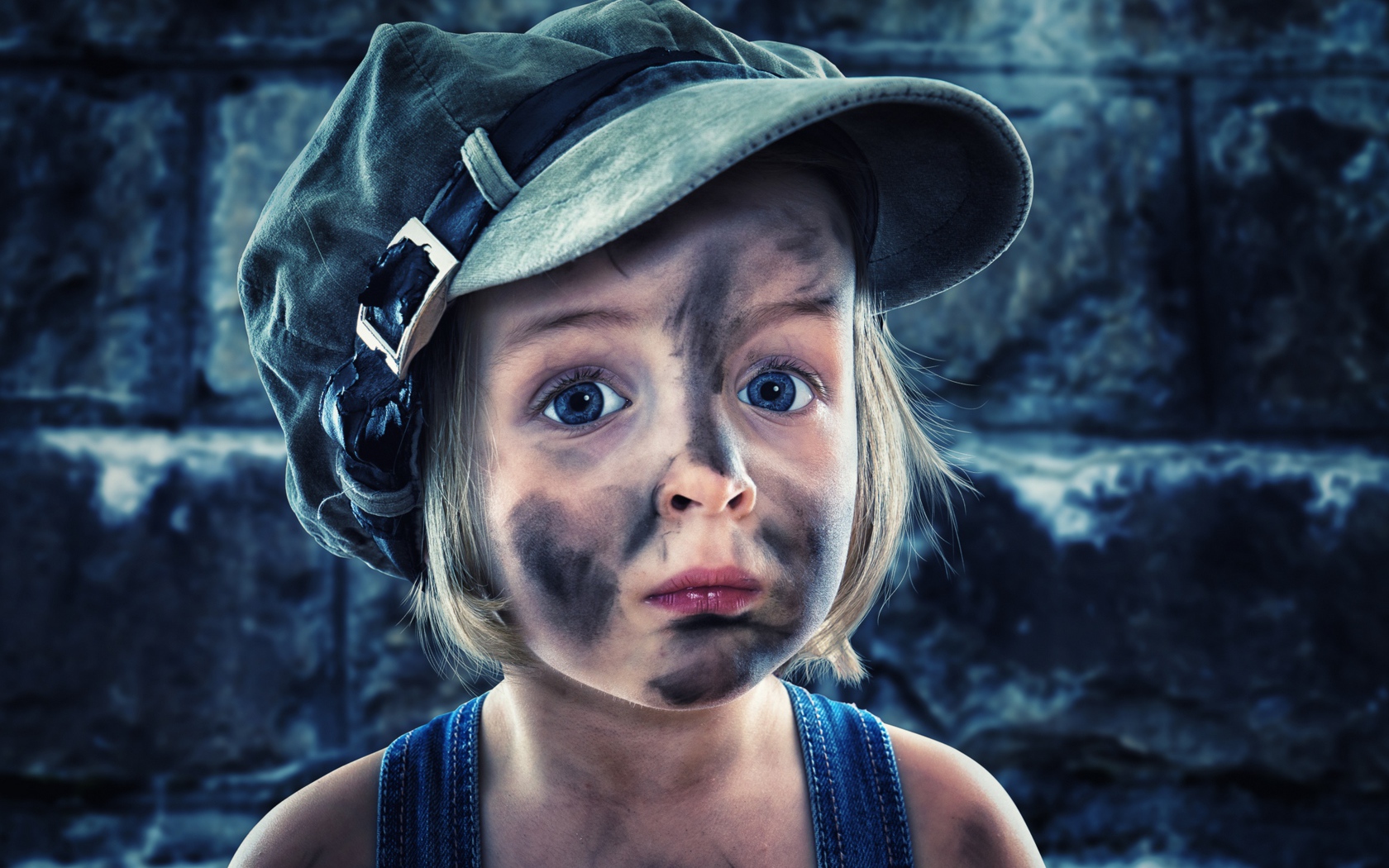 Смешная девочка в кепке с грязным лицом