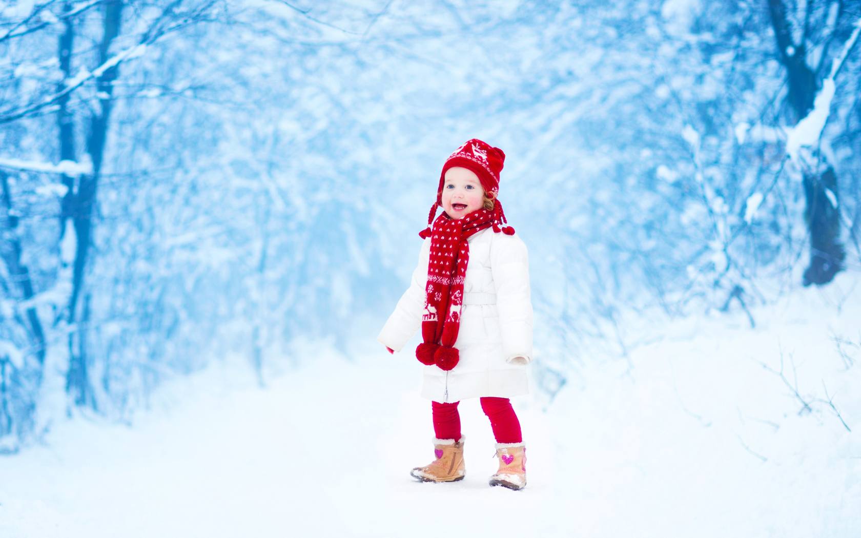 Маленькая веселая девочка в зимнем лесу